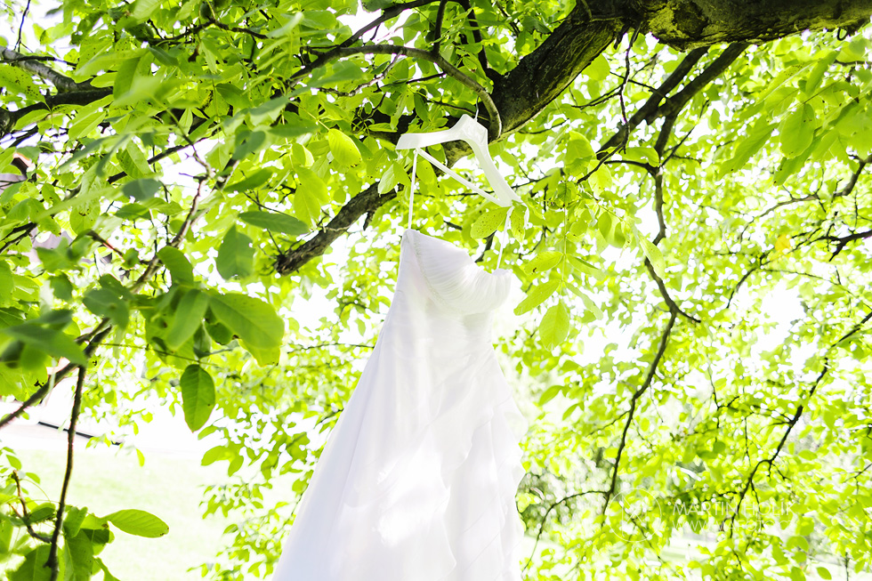 Svatební šaty zavěšené na stromě