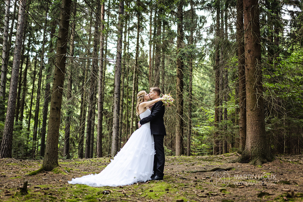 Ženich líbá nevěstu v lese