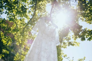 Fotografie svatebních šatů pověšených na stromě